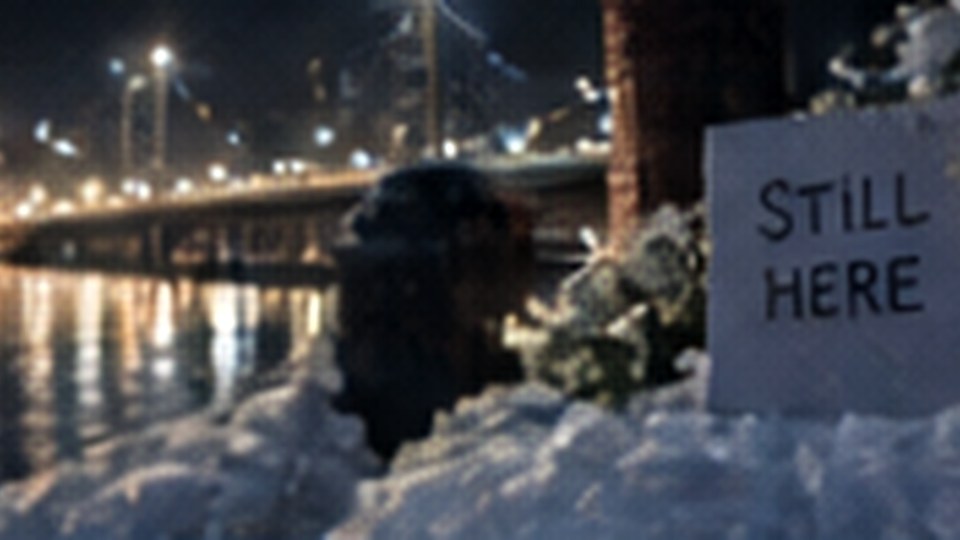 A small memorial beside a city waterfront at night